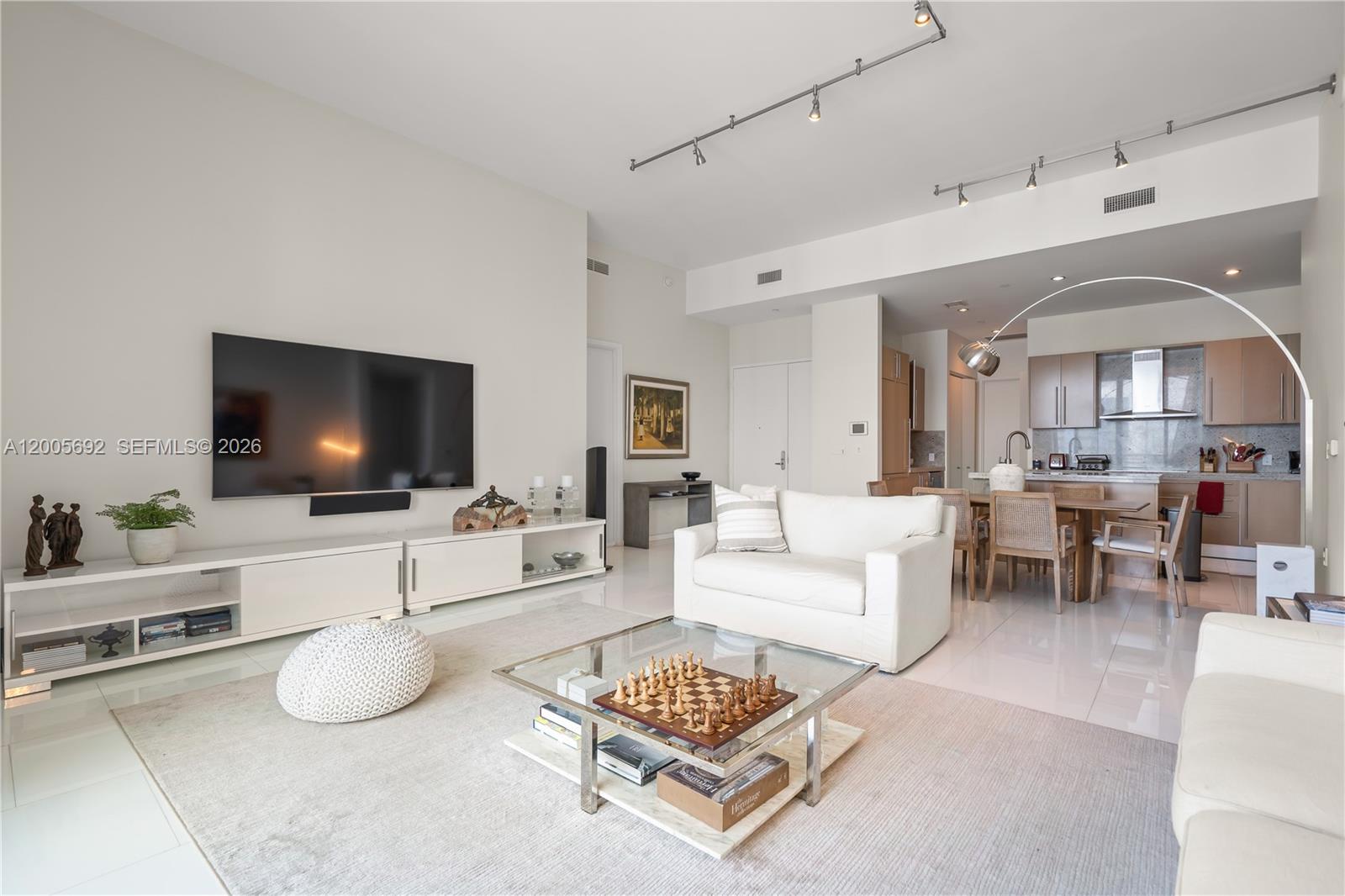 900 Brickell Key Boulevard, Unit 3002 Miami, FL 33131 - Photo 5 of 47 a living room with furniture a flat screen tv and a floor to ceiling window