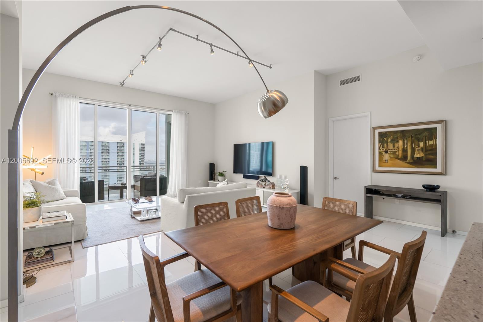 900 Brickell Key Boulevard, Unit 3002 Miami, FL 33131 - Photo 8 of 47 a view of a dining room with furniture window and wooden floor