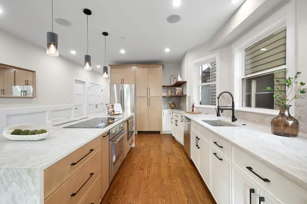 a large kitchen with kitchen island a sink stainless steel appliances and cabinets