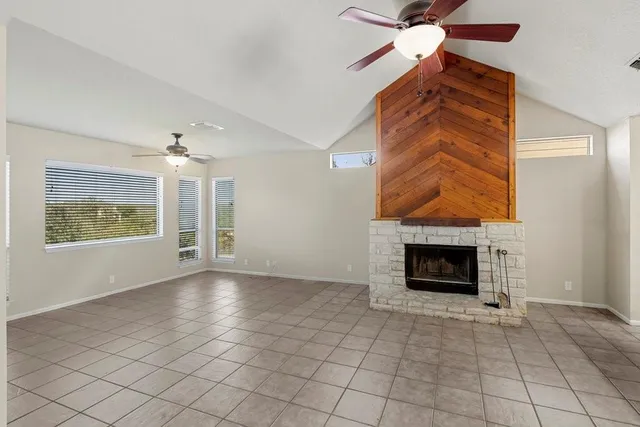 an empty room with windows and fireplace
