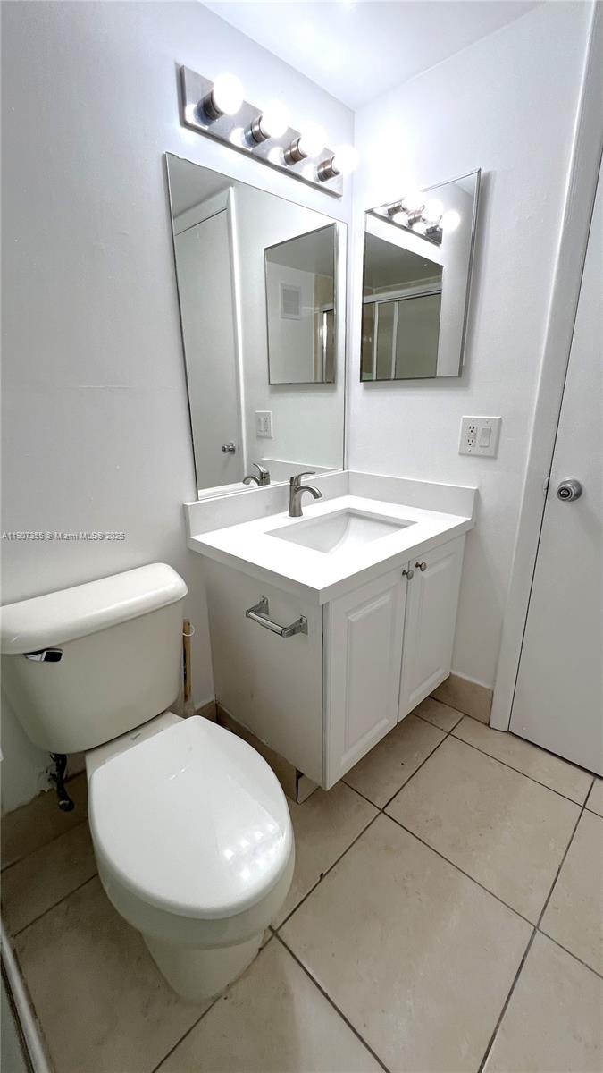 711 North Pine Island Road, Unit 415 Plantation, FL 33324 - Photo 17 of 19 a bathroom with a toilet sink and mirror