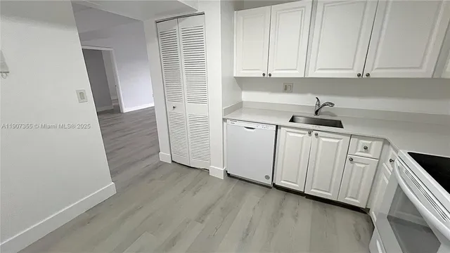 a kitchen with white cabinets and white stainless steel appliances