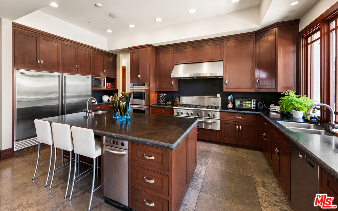 13947 Durham Road Beverly Hills, CA 90210 - Photo 15 of 46 a kitchen with stainless steel appliances kitchen island granite countertop a sink and cabinets