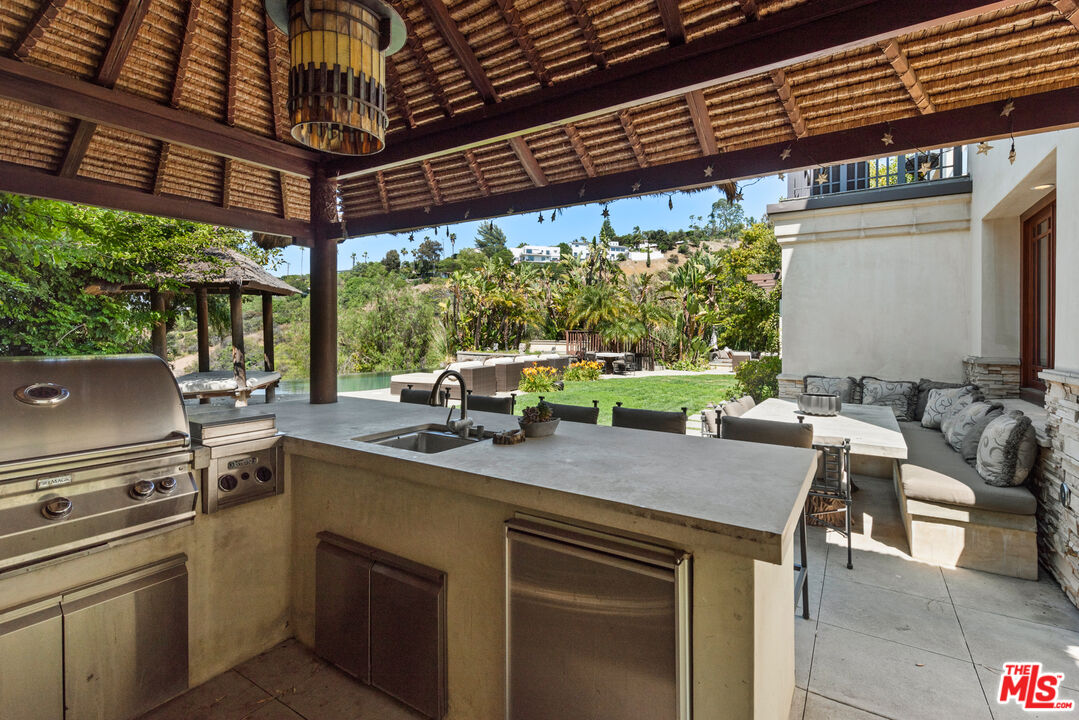 13947 Durham Road Beverly Hills, CA 90210 - Photo 44 of 46 a view of an outdoor kitchen with a table and chairs