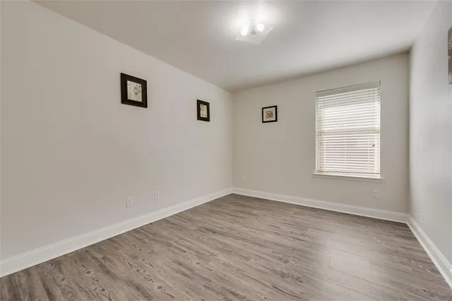 a view of a big room with wooden floor and windows