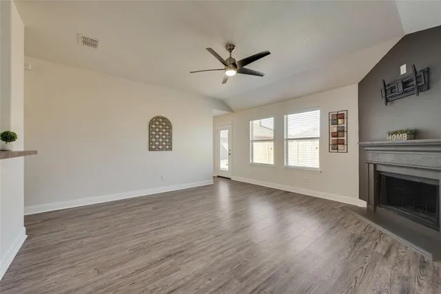 a view of an empty room with a fireplace and a window