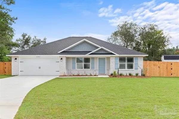 a front view of a house with a yard and trees