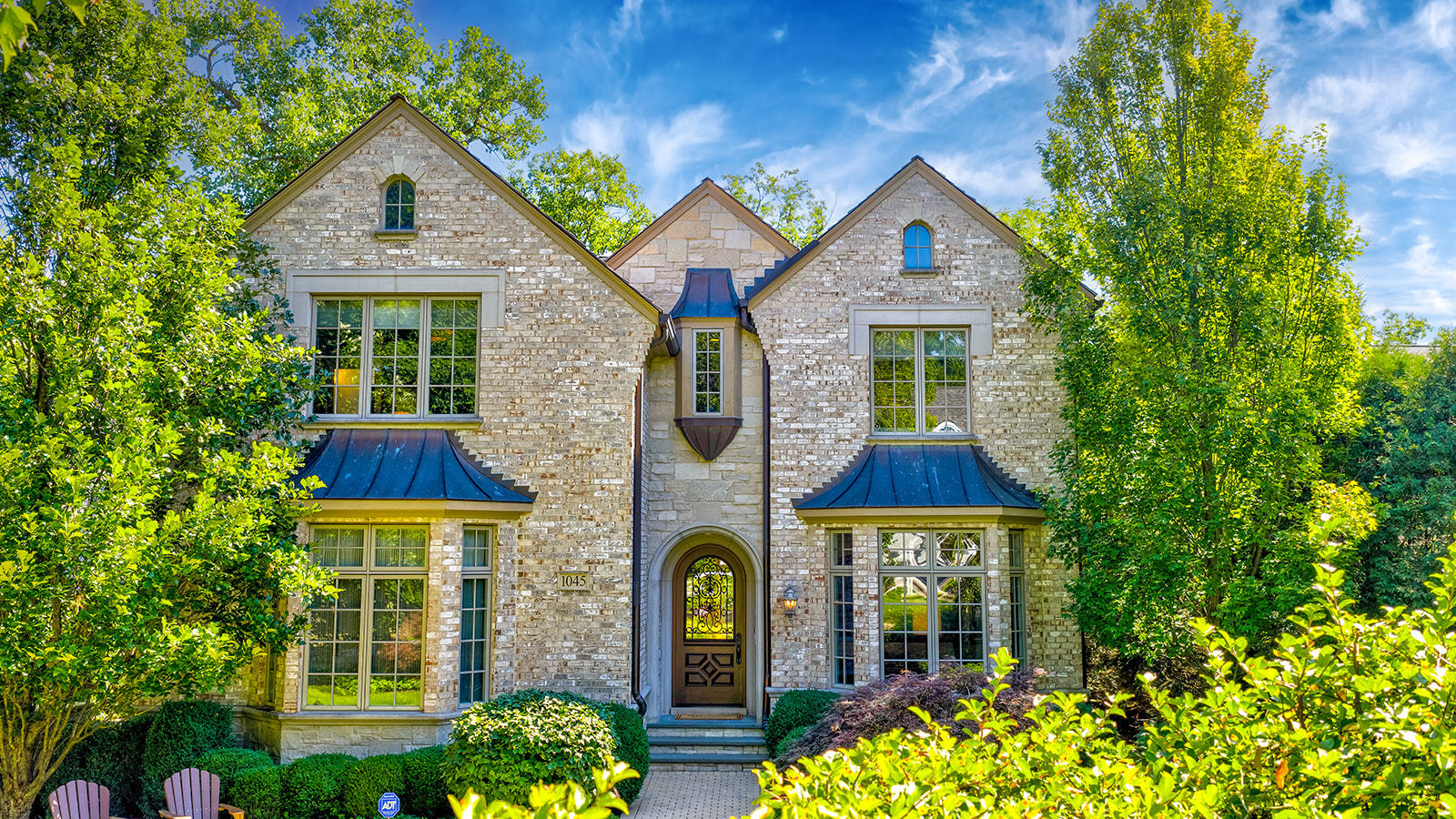 a front view of a house with glass windows and a yard