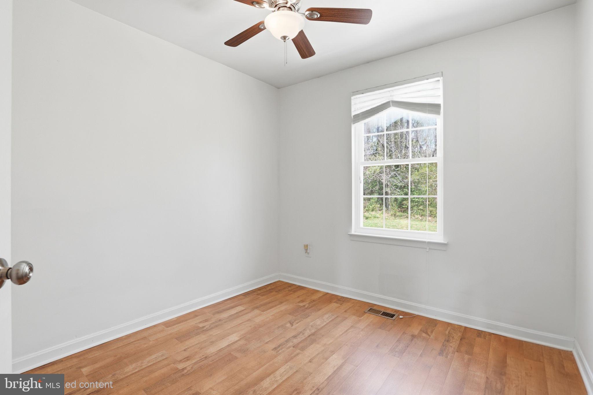 12 Sundown Court Baltimore, MD 21206 - Photo 17 of 29 an empty room with a window and wooden floor