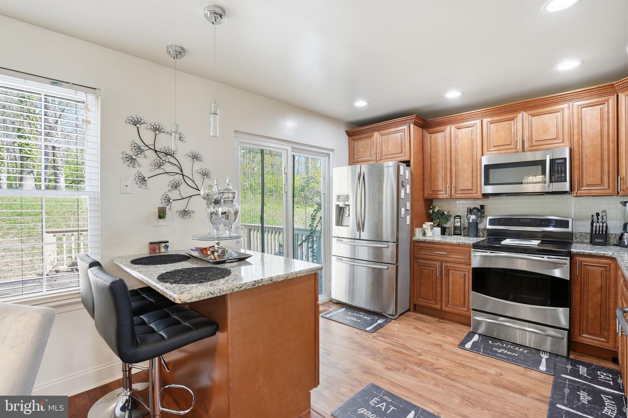 12 Sundown Court Baltimore, MD 21206 - Photo 6 of 29 a kitchen with granite countertop a stove refrigerator and microwave