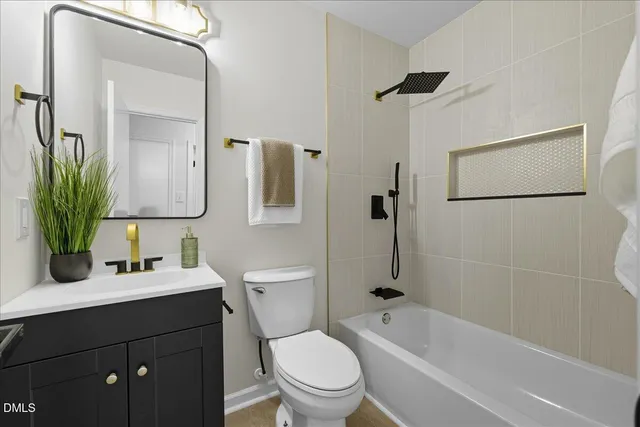a bathroom with a bathtub shower sink vanity mirror and toilet