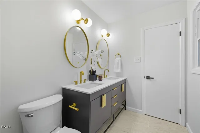 a bathroom with a toilet sink vanity and mirror