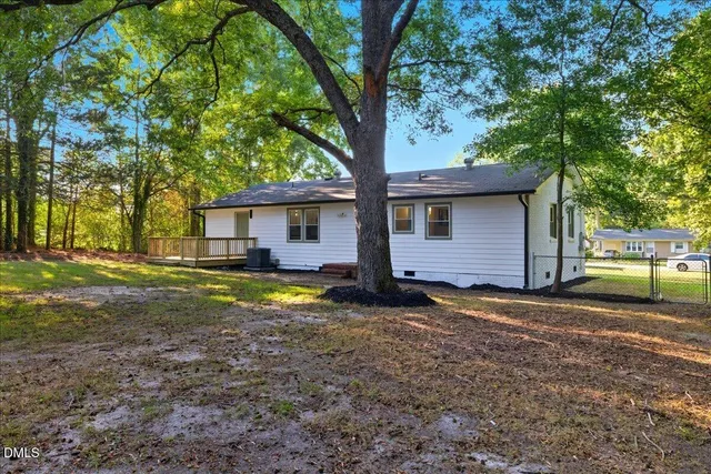 a view of a house with backyard and trees