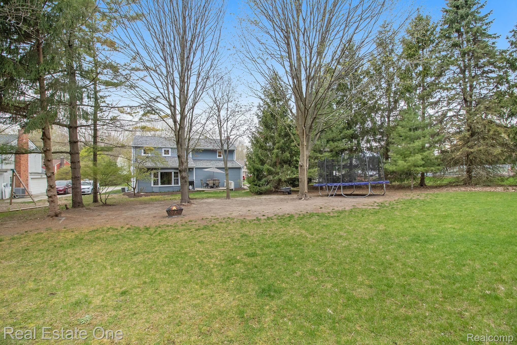 1296 Barneswood Lane Rochester, MI 48306 - Photo 27 of 32 When the foliage is in you'll thing you've gone camping sitting around the fireplace in this large backyard