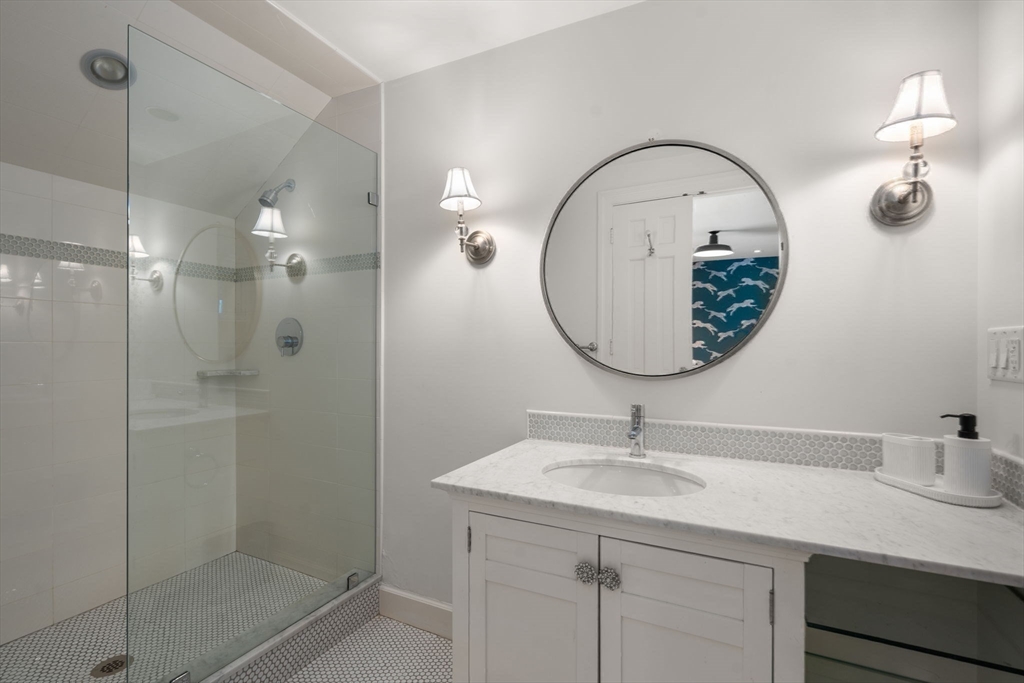 24 Colonial Way Weston, MA 02493 - Photo 22 of 32 a bathroom with a sink a mirror and a shower