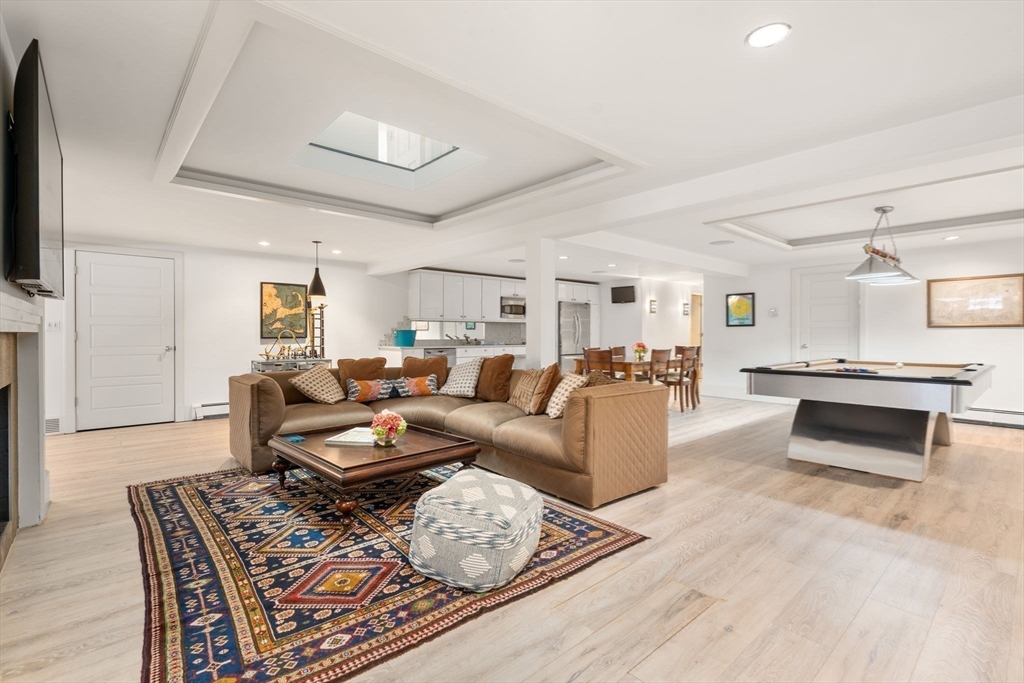 24 Colonial Way Weston, MA 02493 - Photo 27 of 32 a living room with furniture a flat screen tv and a fireplace