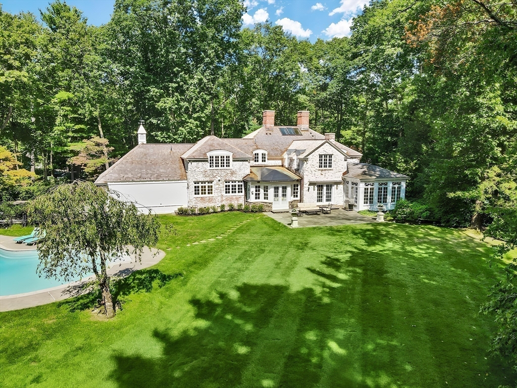 24 Colonial Way Weston, MA 02493 - Photo 3 of 32 a front view of a house with a garden