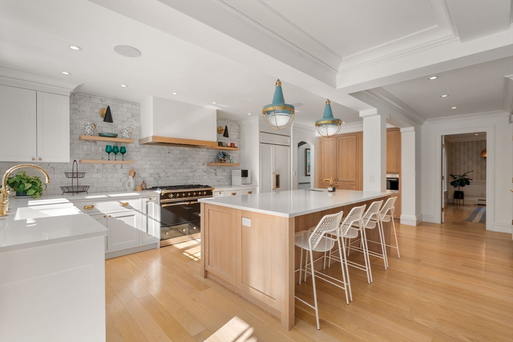 24 Colonial Way Weston, MA 02493 - Photo 10 of 32 a kitchen with stainless steel appliances kitchen island granite countertop a stove a sink a dining table and chairs