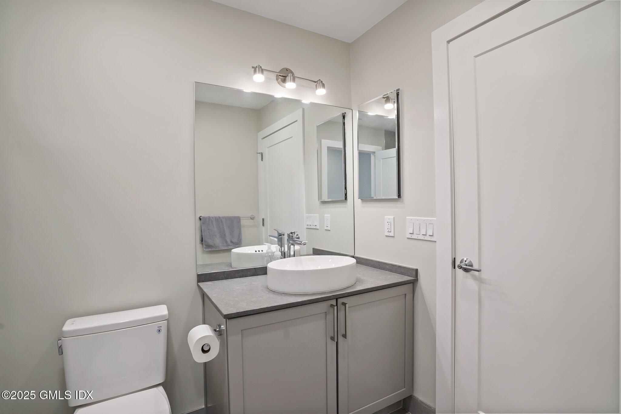 56 Old Field Point Road, Unit 2 Greenwich, CT 06830 - Photo 14 of 20 a bathroom with a sink and a mirror