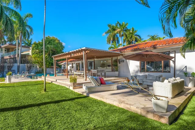 a view of a patio with table and chairs potted plants and palm trees