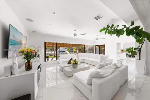 a living room with furniture potted plant and a large window