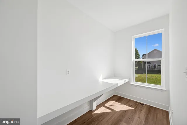 a view of a livingroom with wooden floor a fireplace and window
