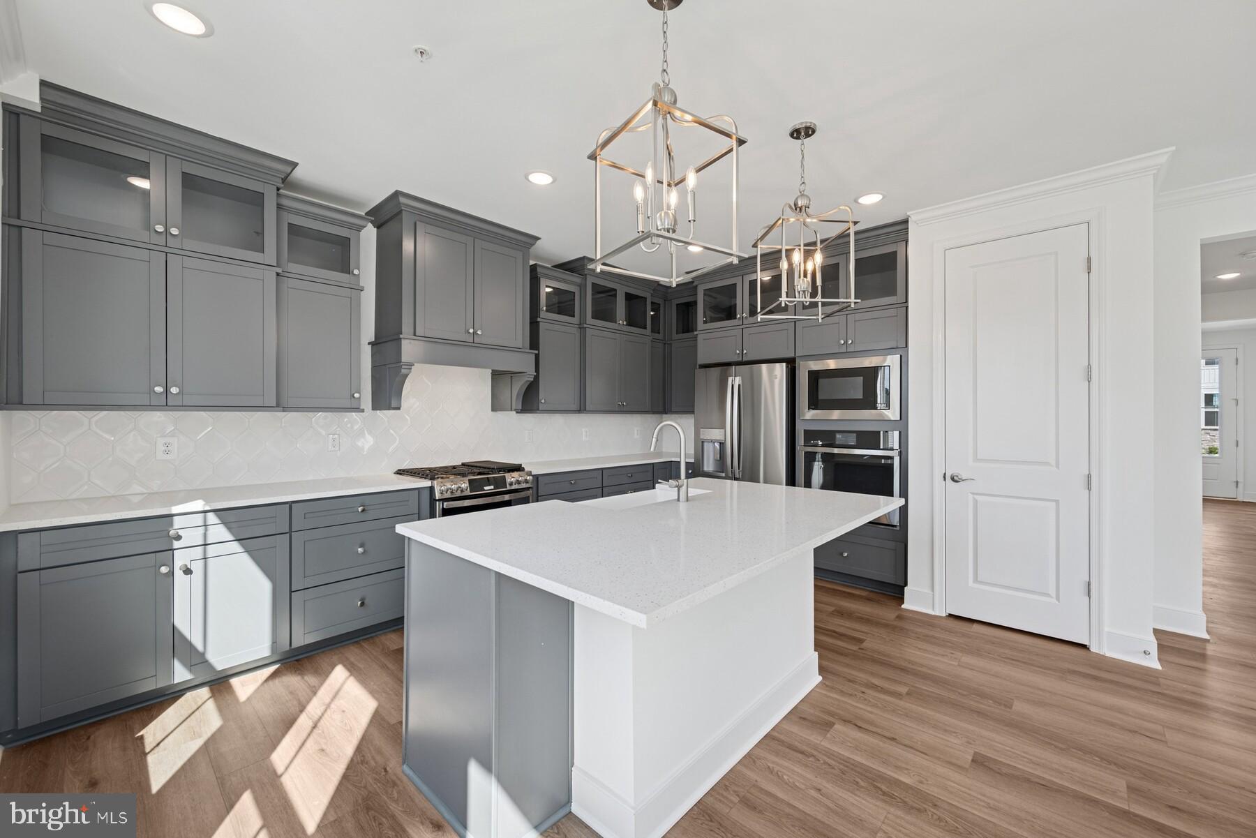2730 Tuscarora Road Adamstown, MD 21710 - Photo 27 of 37 a kitchen with kitchen island a stove a refrigerator and a sink with wooden floor