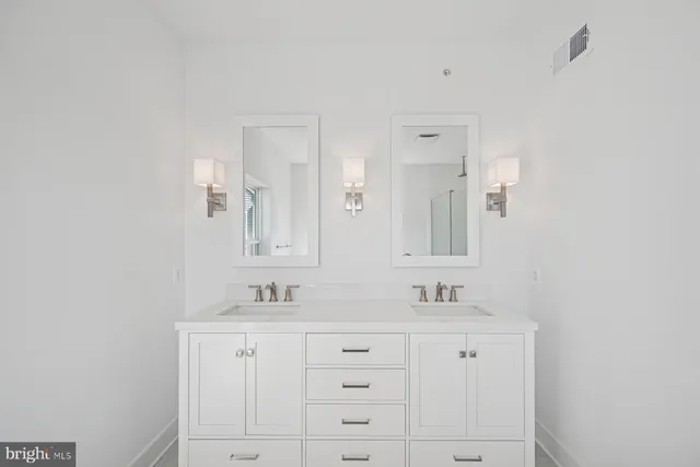 a bathroom with double sink and a mirror
