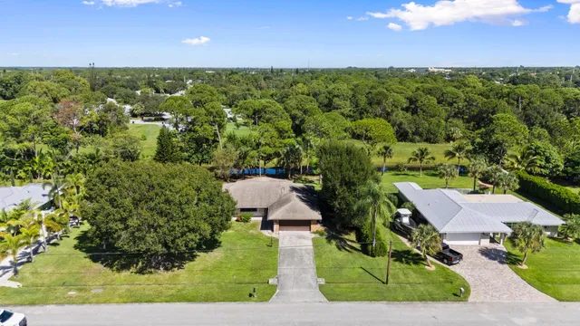 an aerial view of residential houses with outdoor space and trees