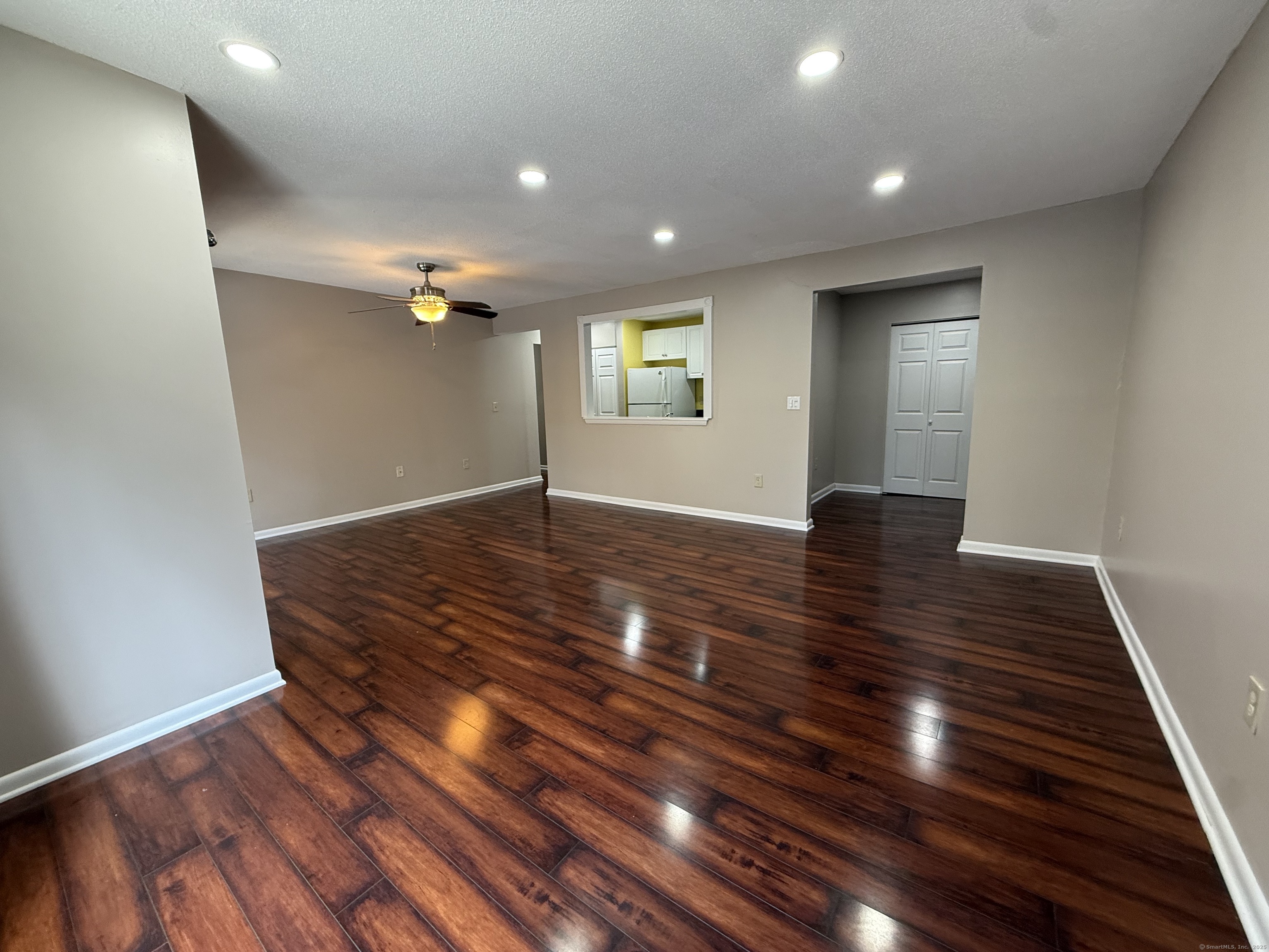 a view of an empty room with wooden floor