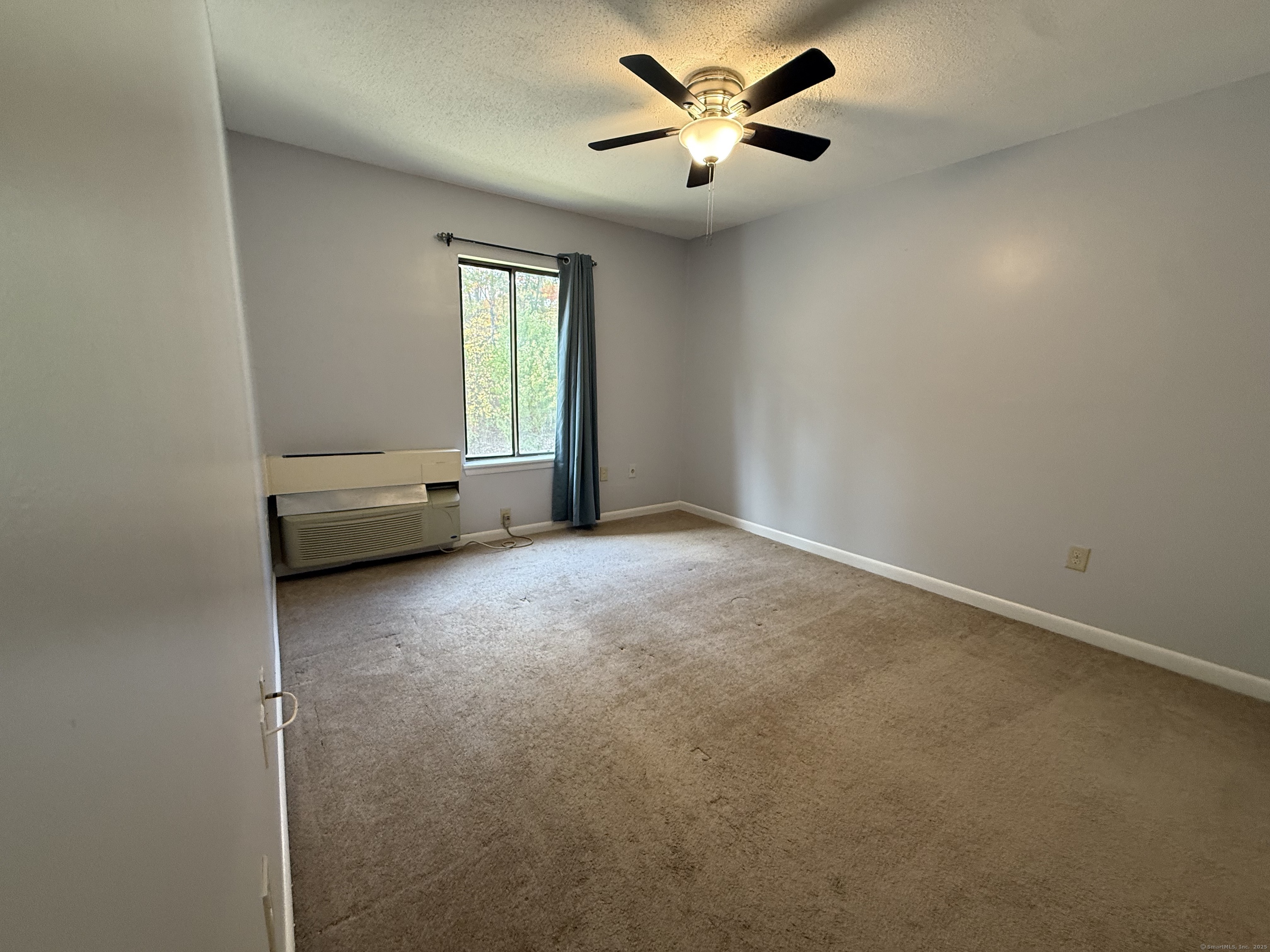 175 Mill Pond Road, Unit 215 Hamden, CT 06514 - Photo 11 of 19 an empty room with windows and fan