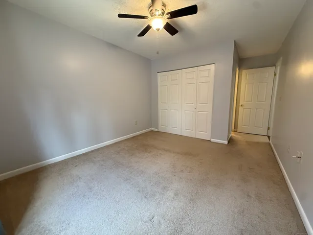 an empty room with chandelier fan