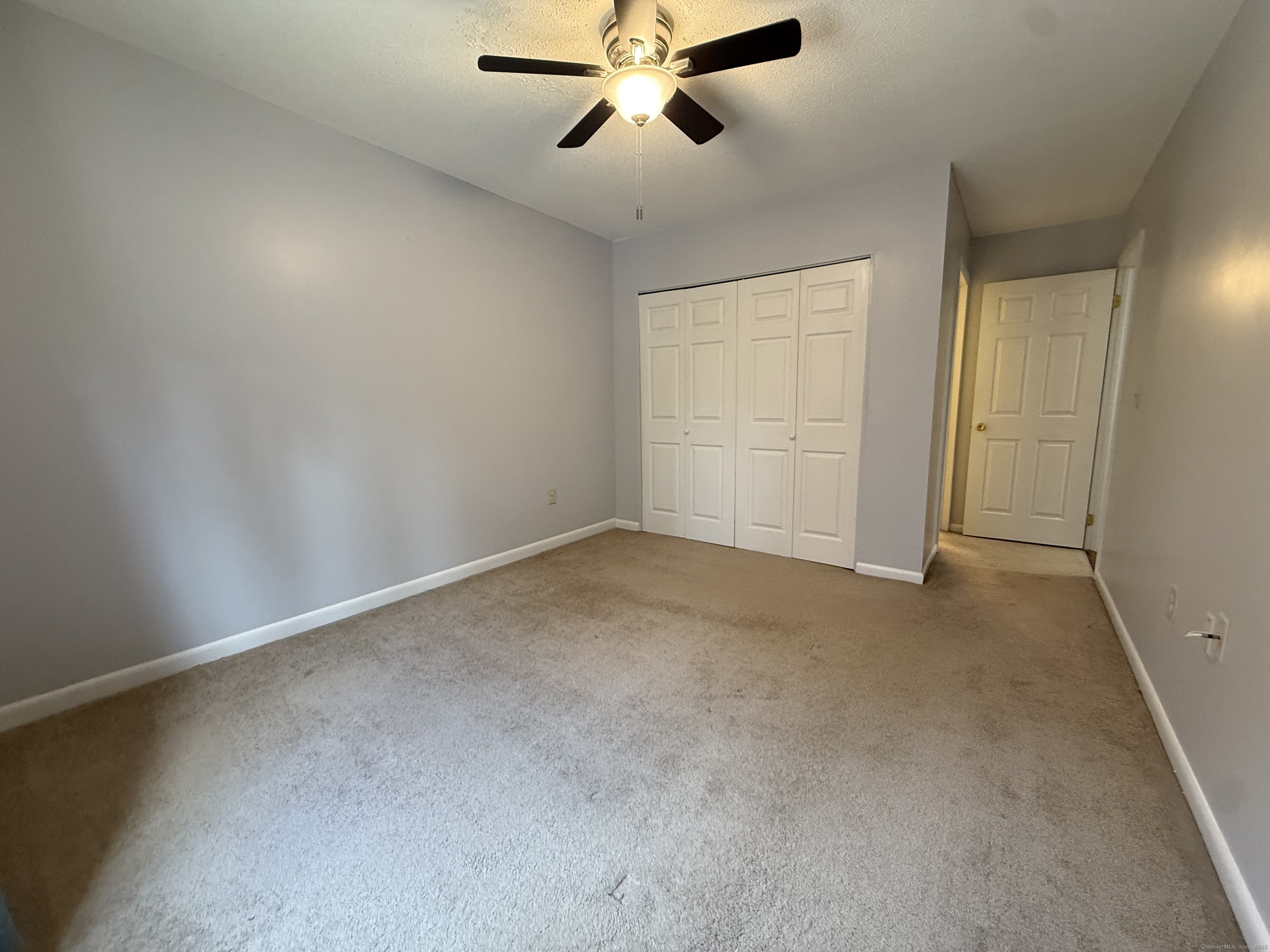 175 Mill Pond Road, Unit 215 Hamden, CT 06514 - Photo 12 of 19 an empty room with chandelier fan