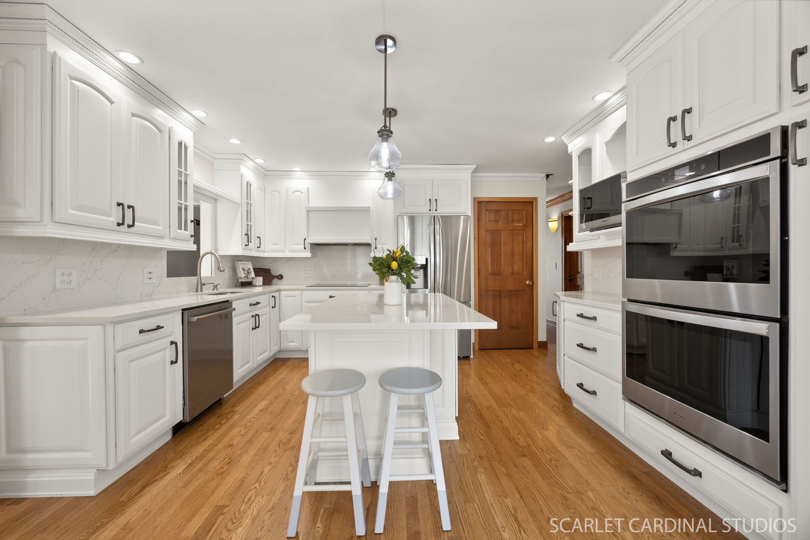 26W275 Tomahawk Drive Wheaton, IL 60189 - Photo 6 of 41 a kitchen with stainless steel appliances kitchen island granite countertop a stove a sink a refrigerator and white cabinets with wooden floor