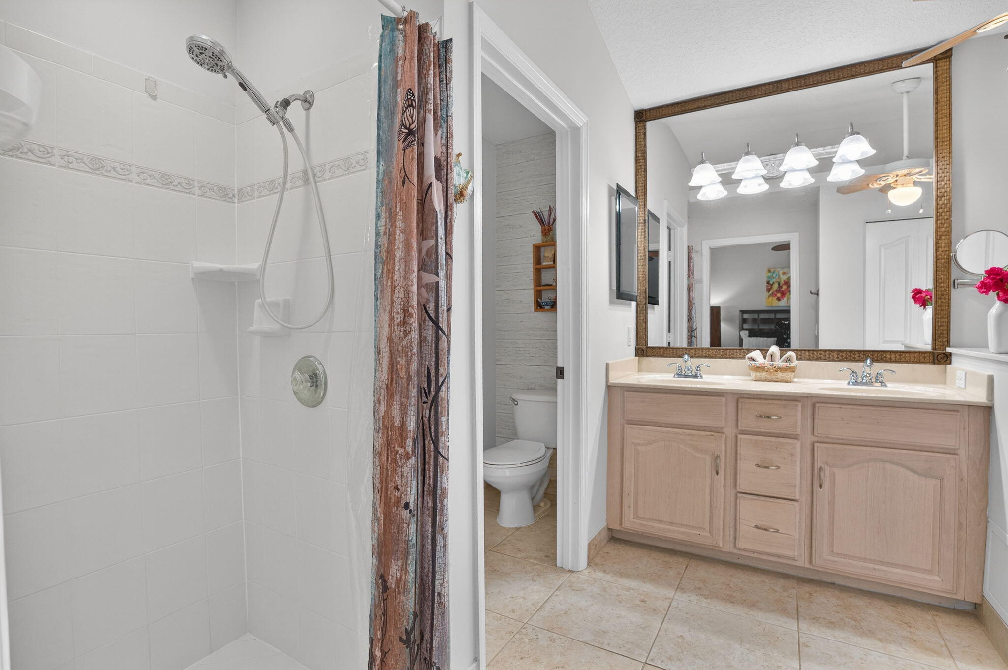 9275 Southeast Mercury Street Hobe Sound, FL 33455 - Photo 11 of 65 a bathroom with a granite countertop sink a toilet and a mirror