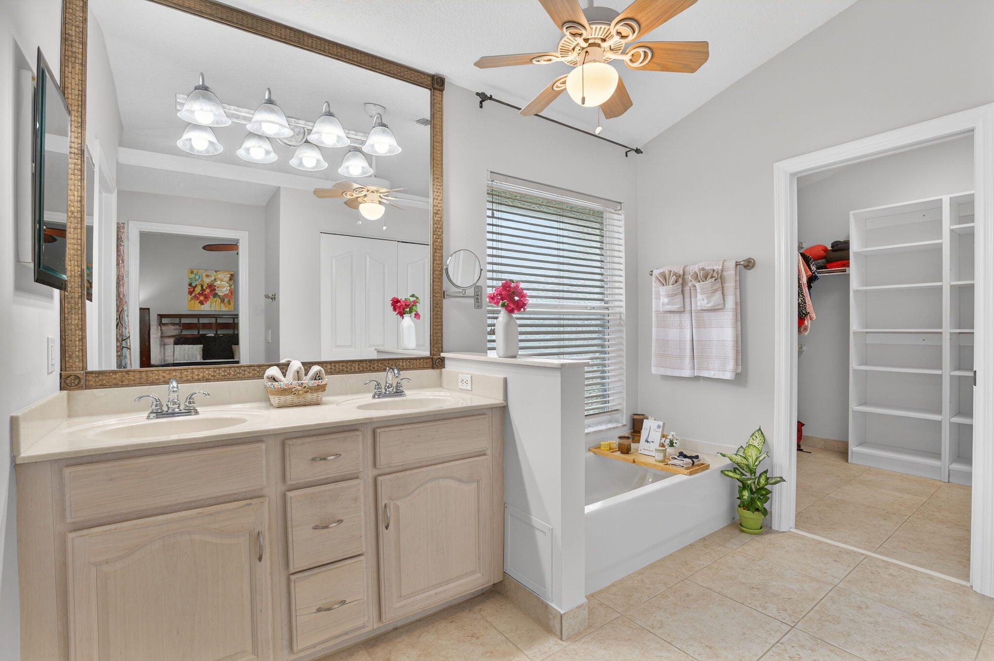 9275 Southeast Mercury Street Hobe Sound, FL 33455 - Photo 12 of 65 a bathroom with a sink a vanity a mirror a bathtub and a shower