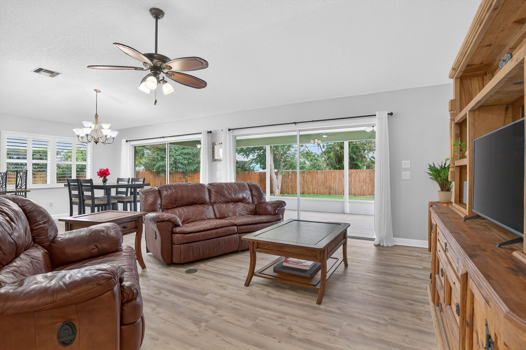 9275 Southeast Mercury Street Hobe Sound, FL 33455 - Photo 18 of 65 a living room with furniture a ceiling fan and a flat screen tv