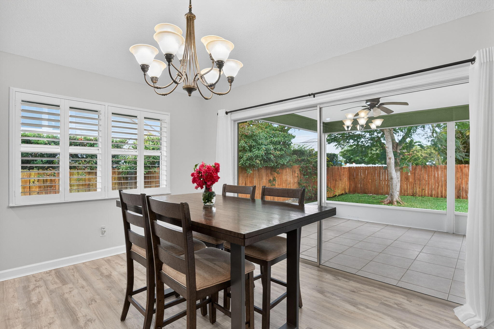 9275 Southeast Mercury Street Hobe Sound, FL 33455 - Photo 23 of 65 a view of a dining room with furniture a chandelier and wooden floor