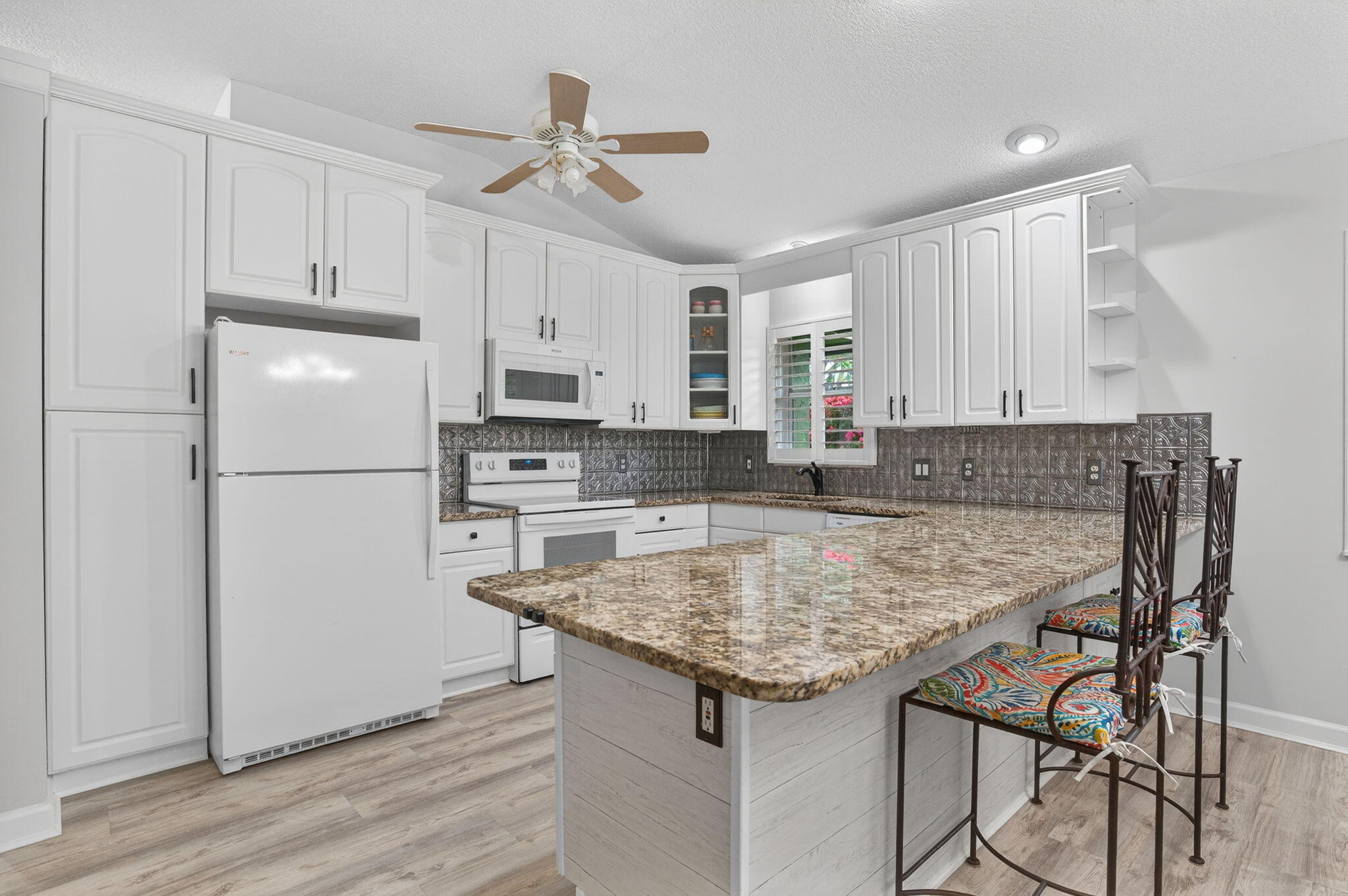 9275 Southeast Mercury Street Hobe Sound, FL 33455 - Photo 24 of 65 a kitchen with kitchen island a sink stove and refrigerator