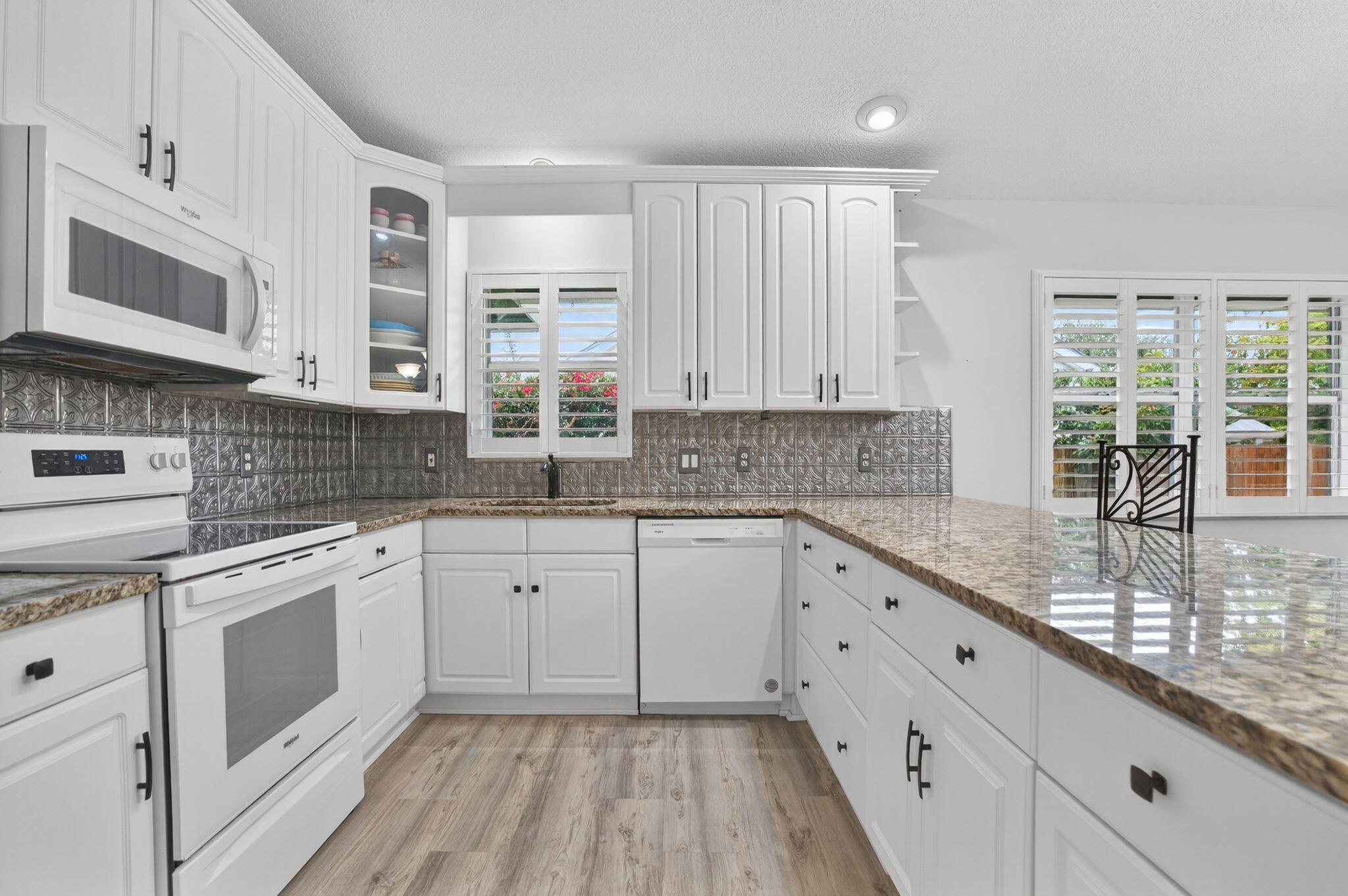 9275 Southeast Mercury Street Hobe Sound, FL 33455 - Photo 26 of 65 a kitchen with granite countertop white cabinets stainless steel appliances a sink and window