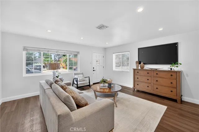 a living room with furniture a window and a flat screen tv