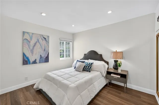 a bedroom with a bed and a painting on the wall