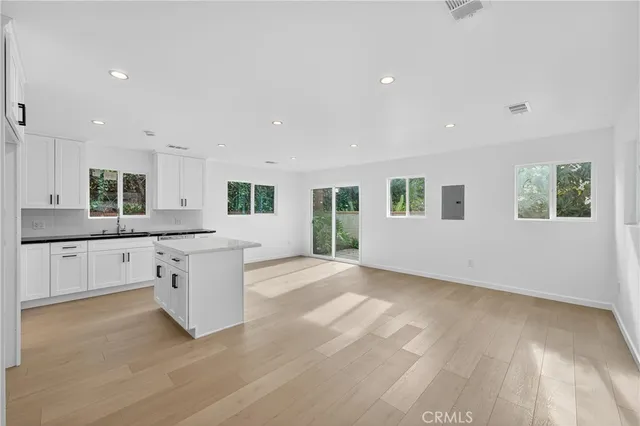 a kitchen with granite countertop white cabinets white appliances and a sink