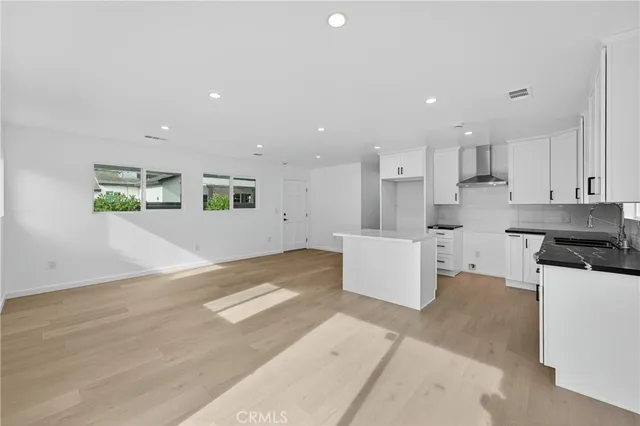 a kitchen with white cabinets and sink