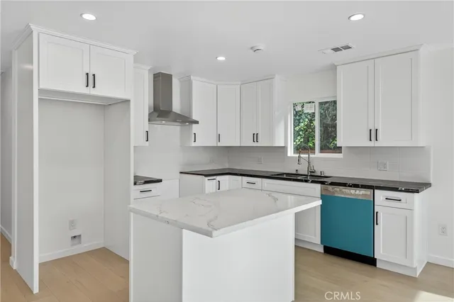 a front view of a house with plants and a bench