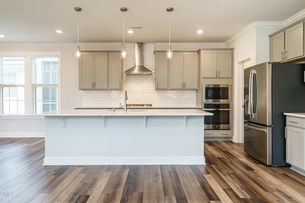 a kitchen with stainless steel appliances a refrigerator and a stove top oven
