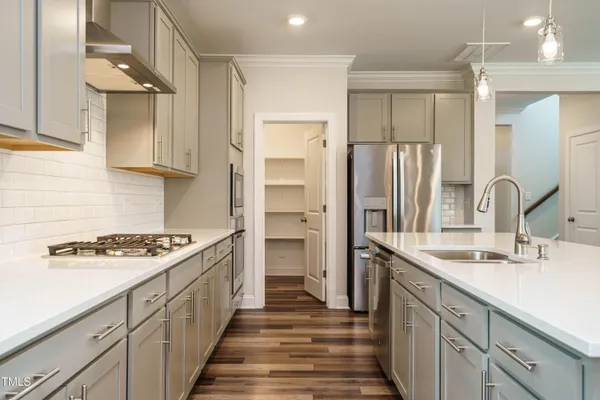 a kitchen with stainless steel appliances granite countertop a sink stove and refrigerator