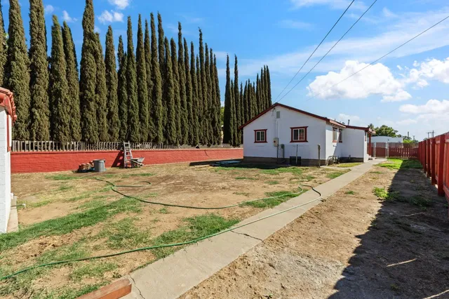 a view of swimming pool with lawn chairs and plants