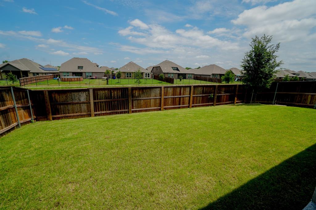 1309 Old Rocksprings Pass Mansfield, TX 76063 - Photo 32 of 36 Expansive grassy yard with a tall wood privacy fence