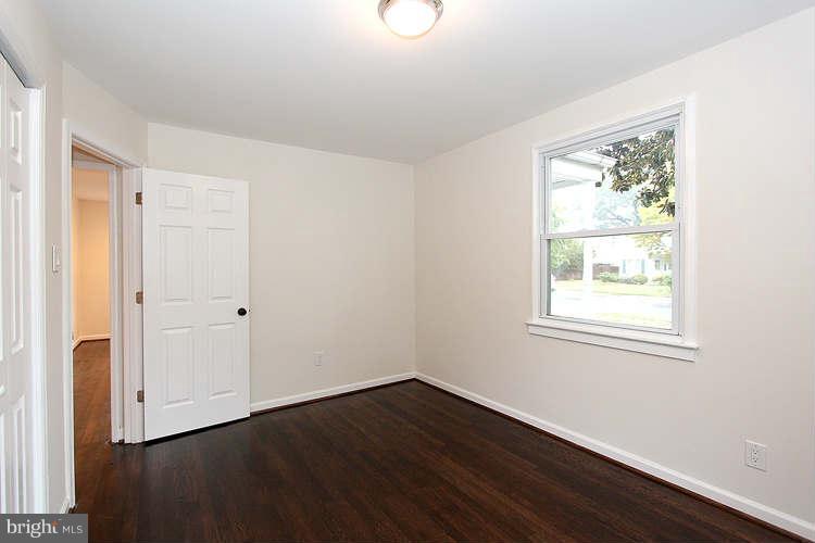 8129 Bullneck Road Baltimore, MD 21222 - Photo 18 of 30 a view of an empty room with wooden floor and a window